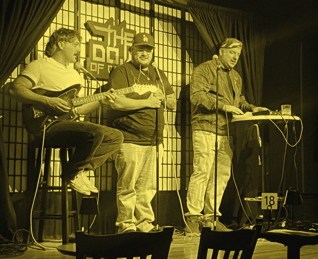 Three performers on stage at the Dojo of Comedy